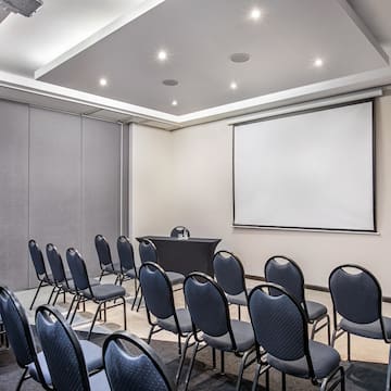 a room with a projection screen and chairs