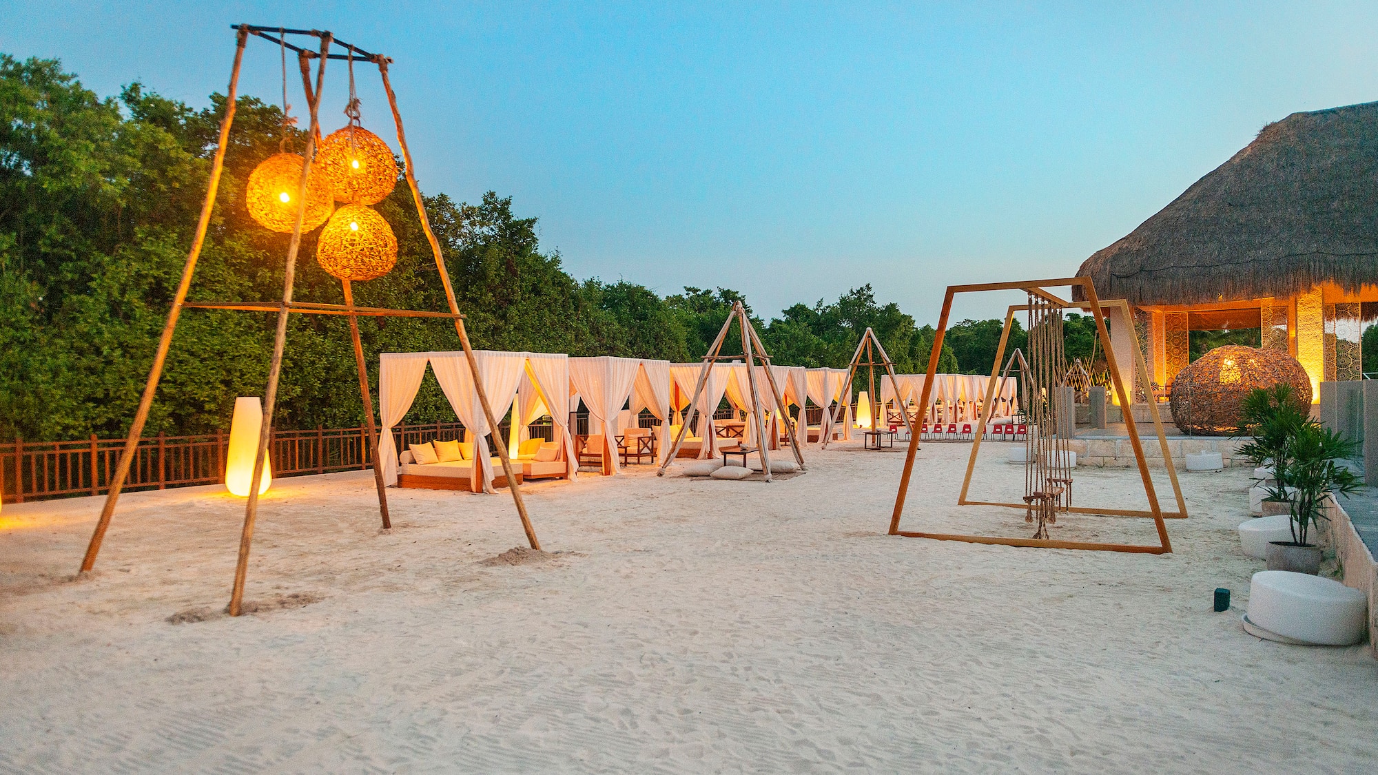 a group of tents and swings in a sandy area
