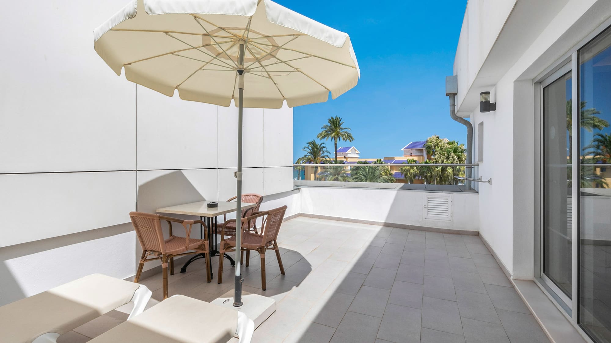 a patio with chairs and umbrella