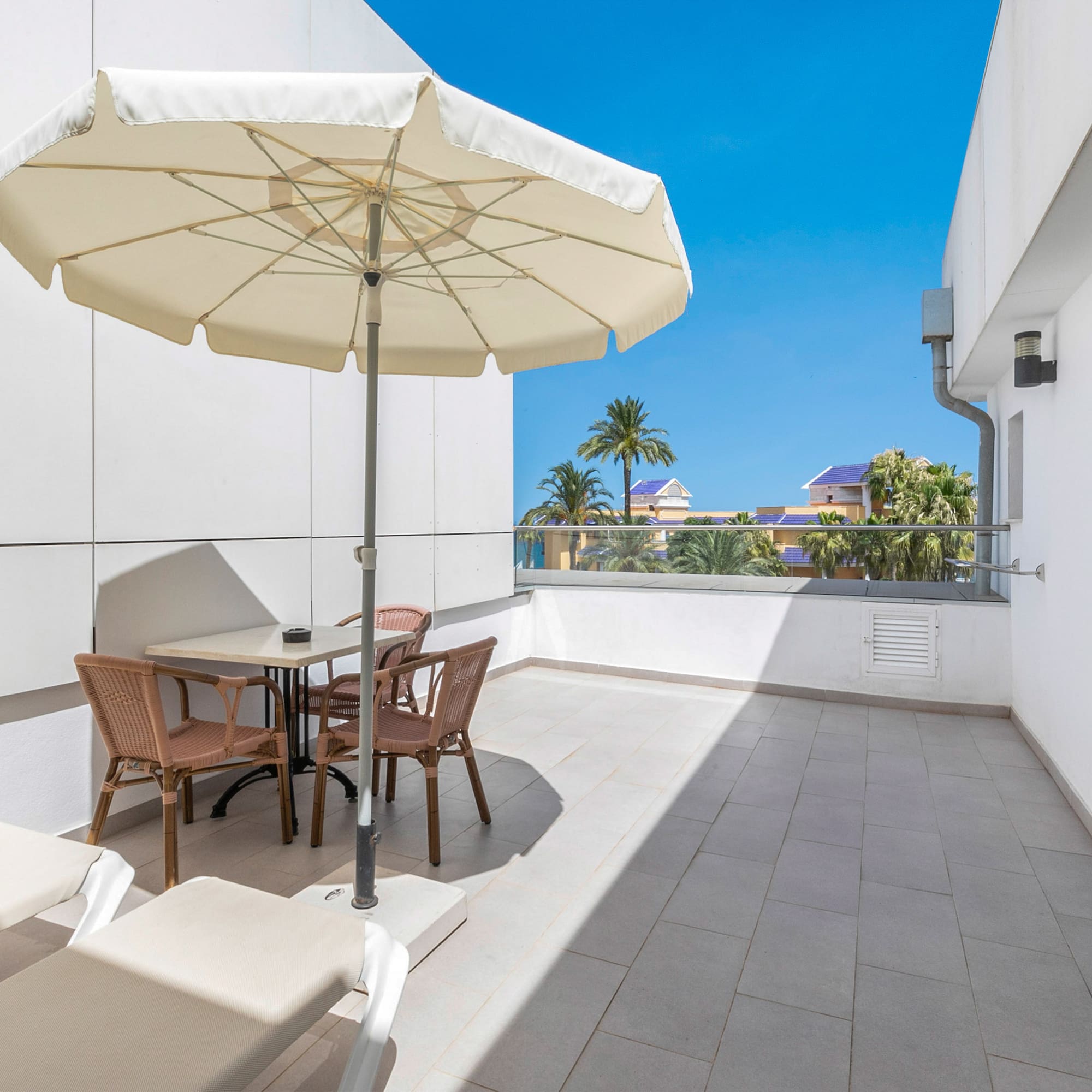 a patio with chairs and umbrella