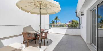 a patio with chairs and umbrella