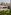 Jardín de villa de lujo con piscina, palmeras, tumbonas y hamaca.