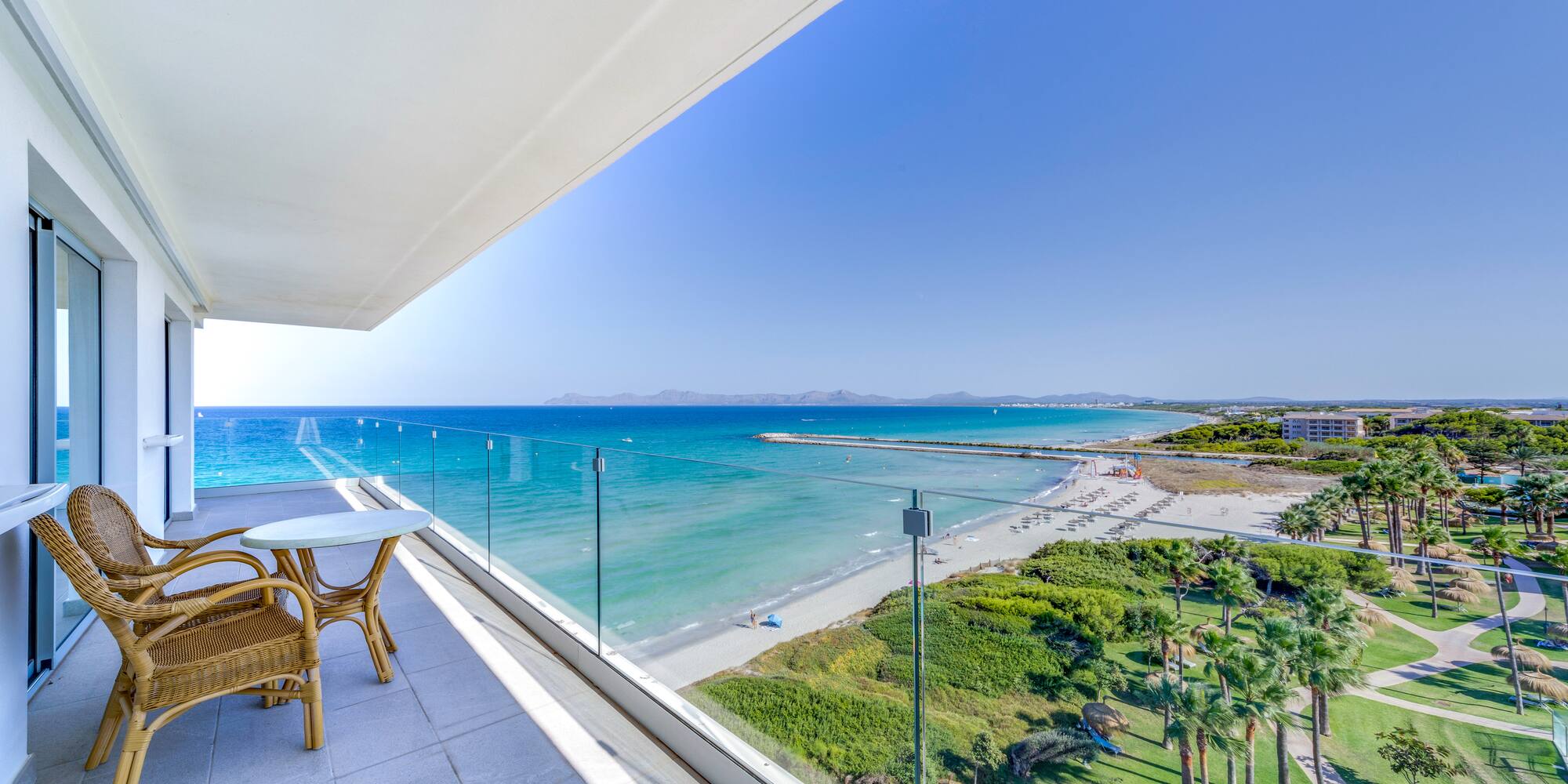 a balcony with a view of the beach and palm trees