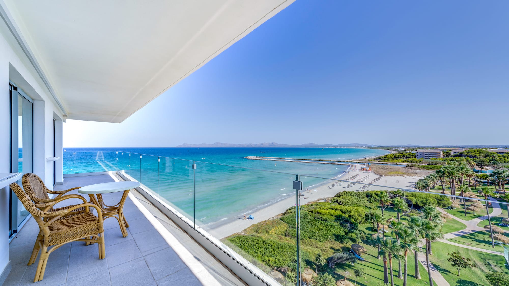 a balcony with a view of the beach and palm trees