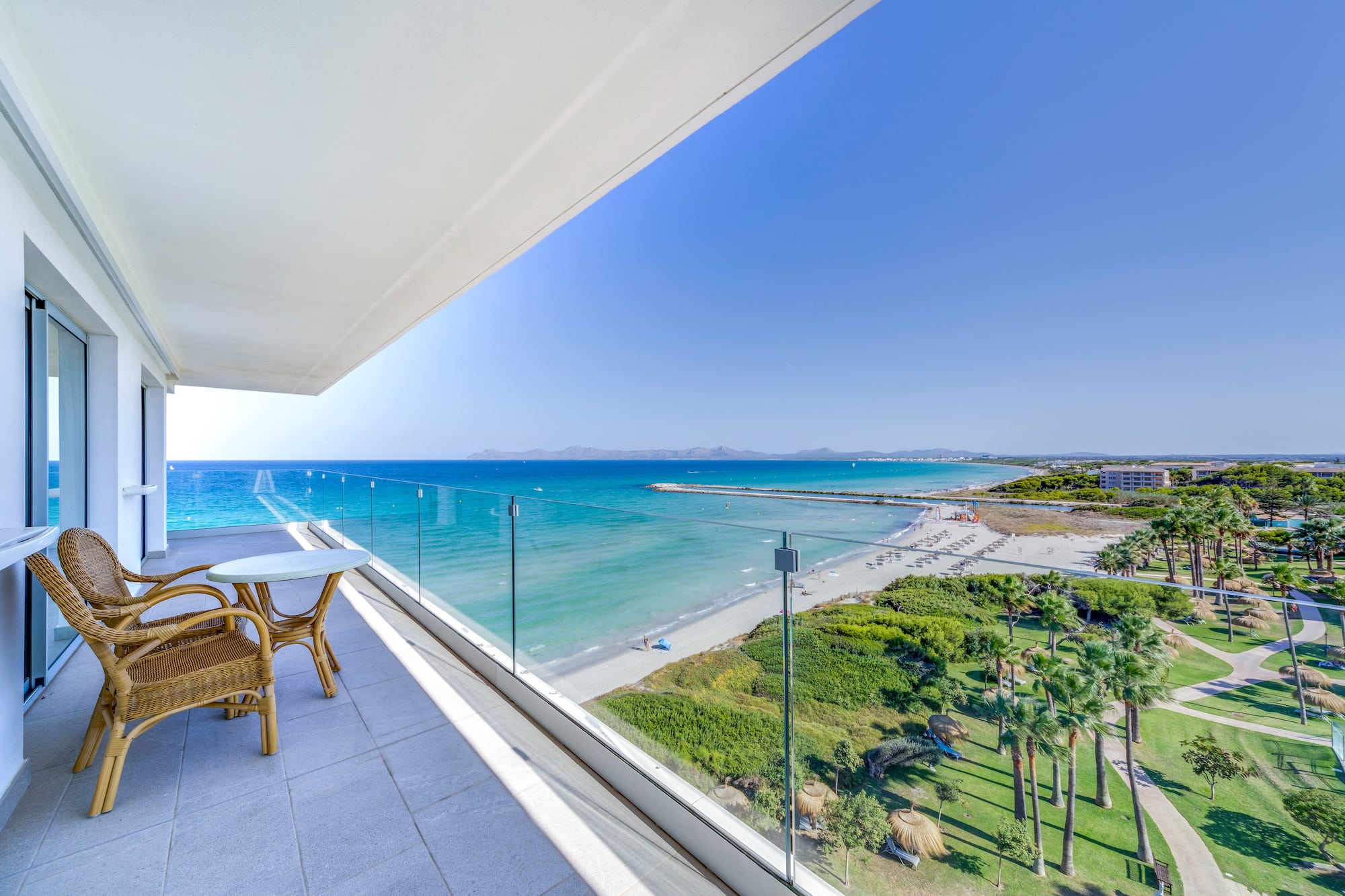 a balcony with a view of the beach and palm trees