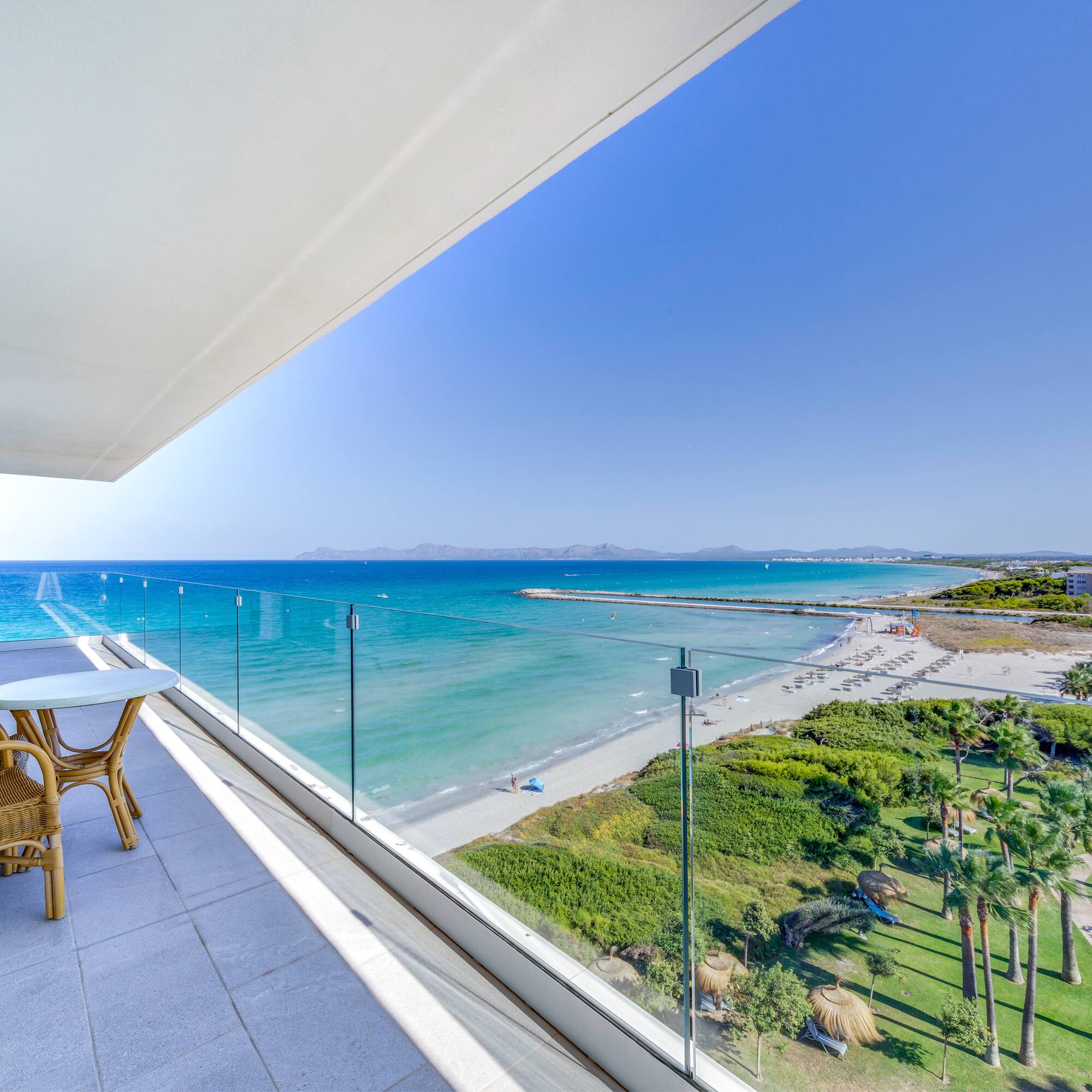 a balcony with a view of the beach and palm trees