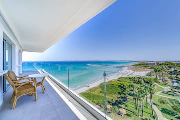 a balcony with a view of the beach and palm trees