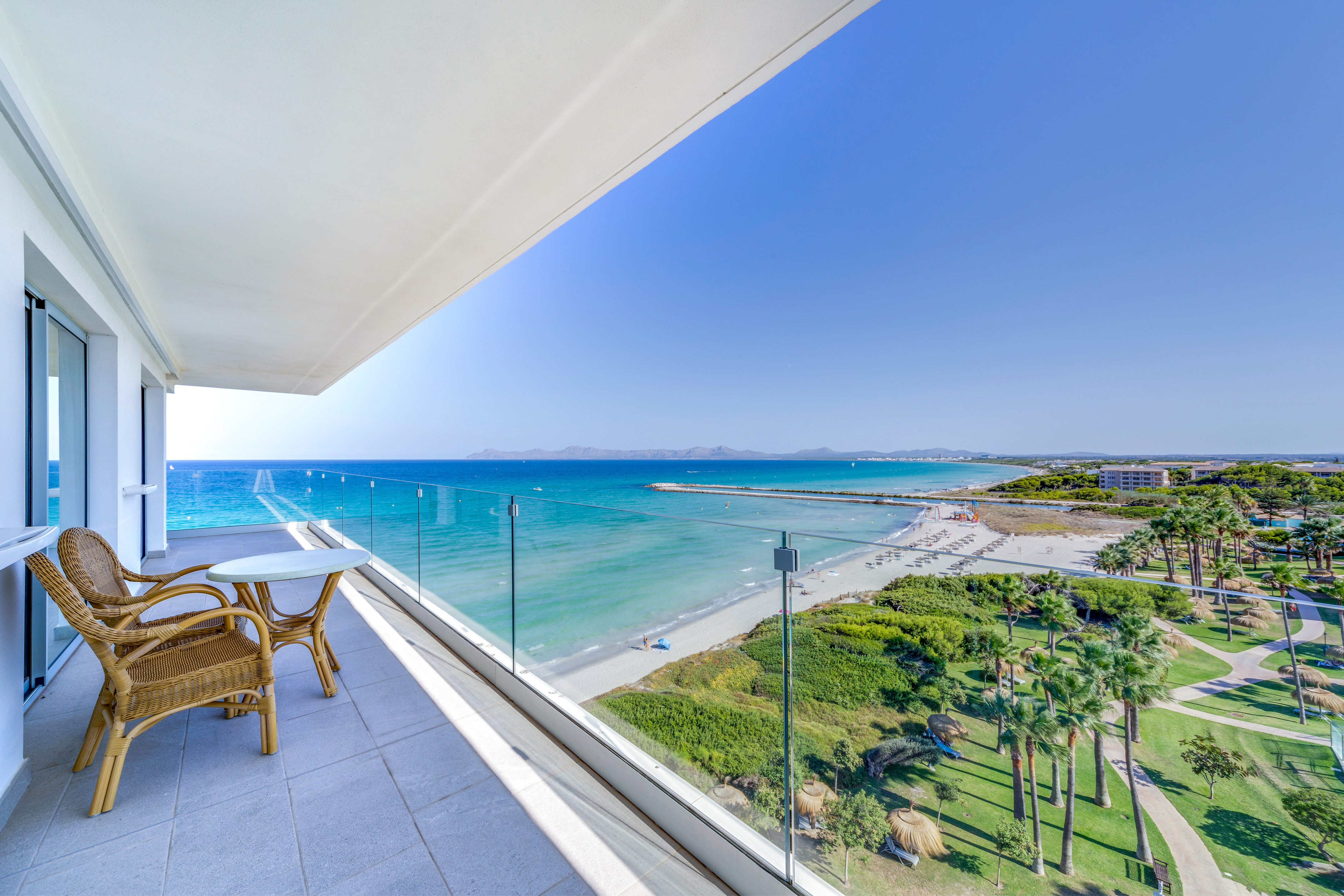a balcony with a view of the beach and palm trees