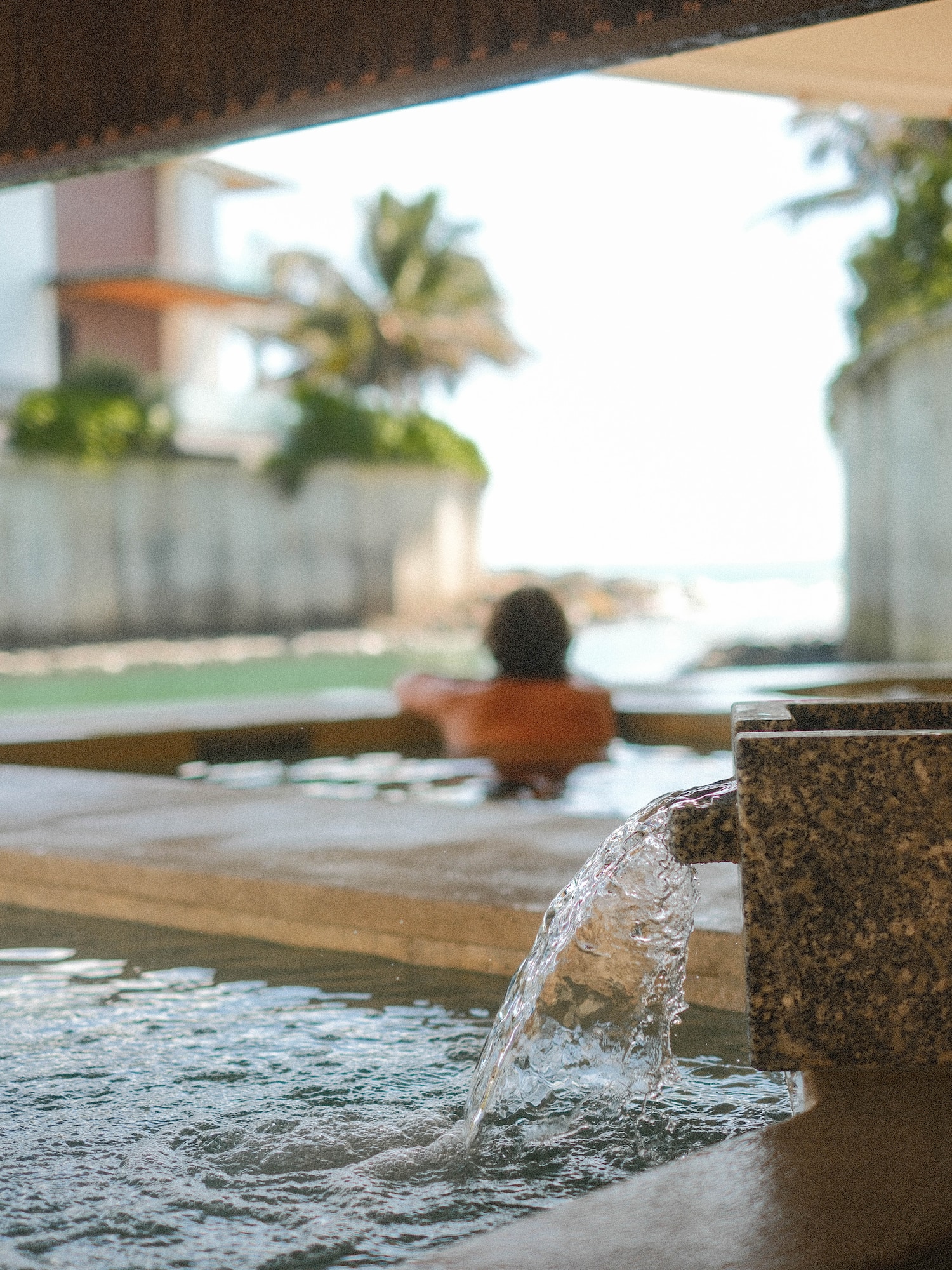 a person in a pool with water coming out of it