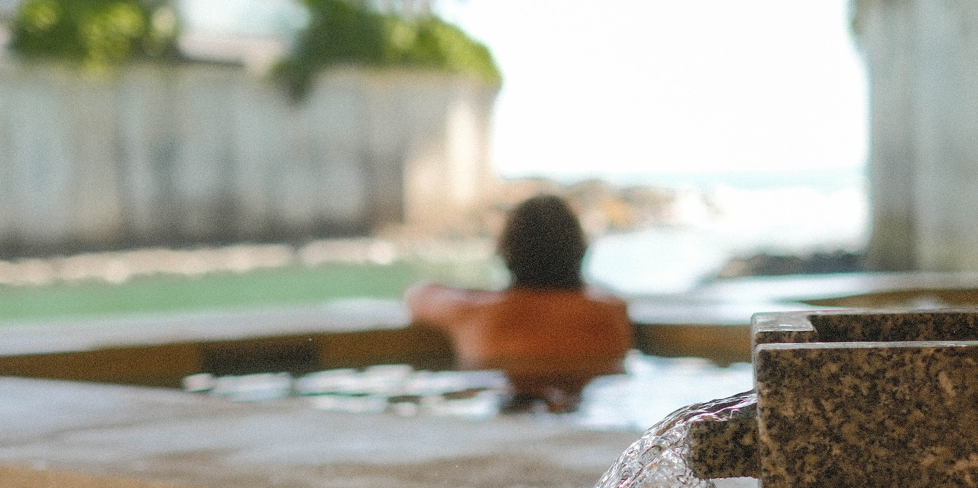 a person in a pool with water coming out of it