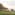 a group of people sitting on a blanket on a grassy field