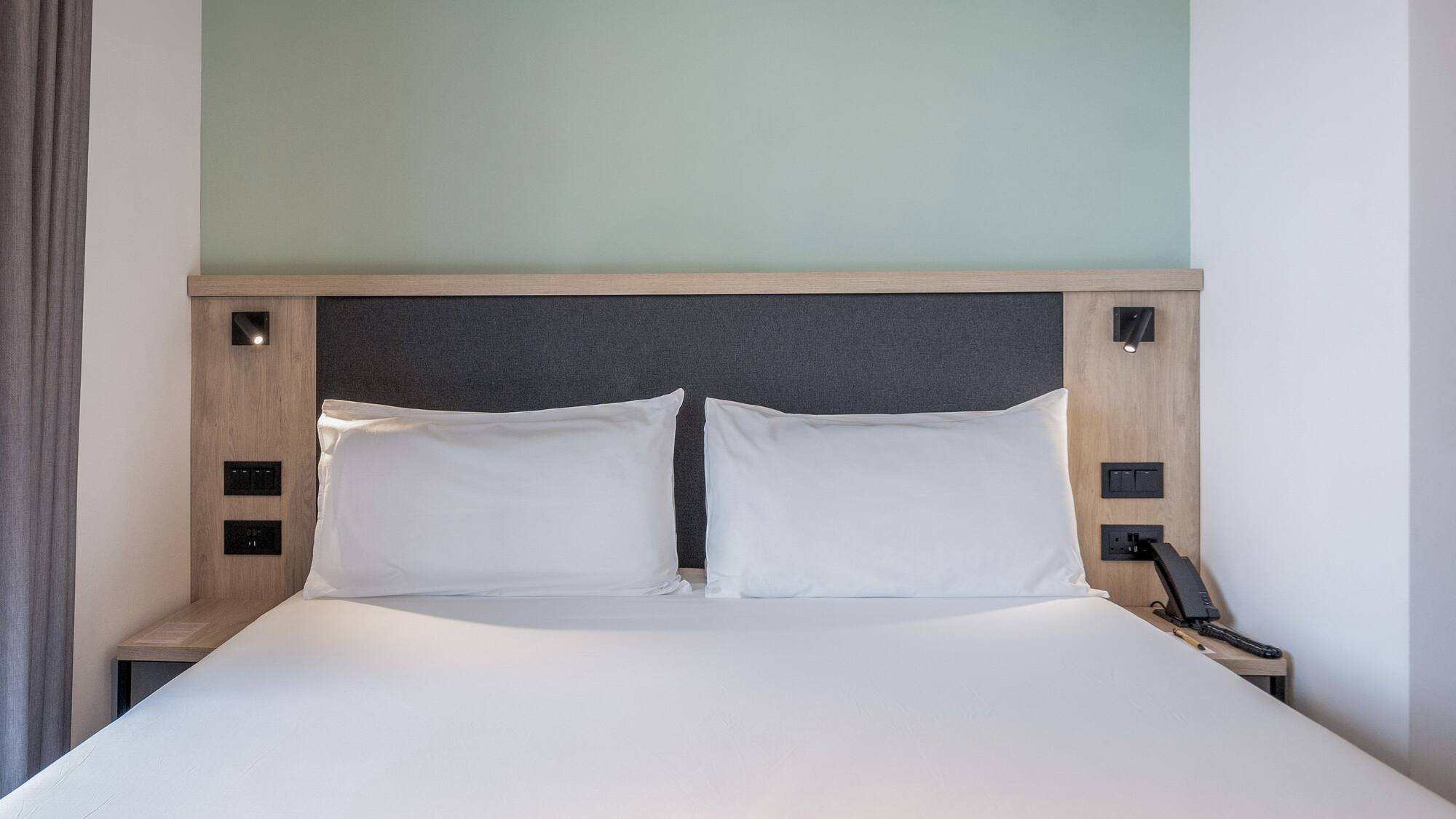 a bed with white sheets and a wooden headboard