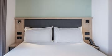 a bed with white sheets and a wooden headboard