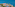 Coastal resort with palm trees, swimming pools, lighthouse, and blue sea.