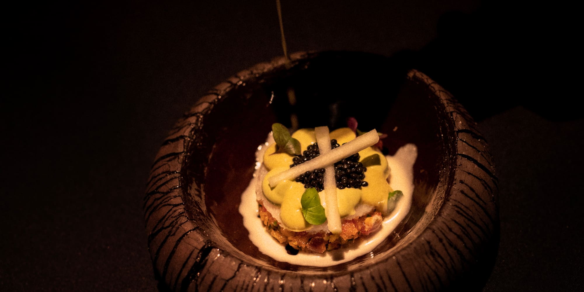 a bowl of food with a white liquid being poured into it
