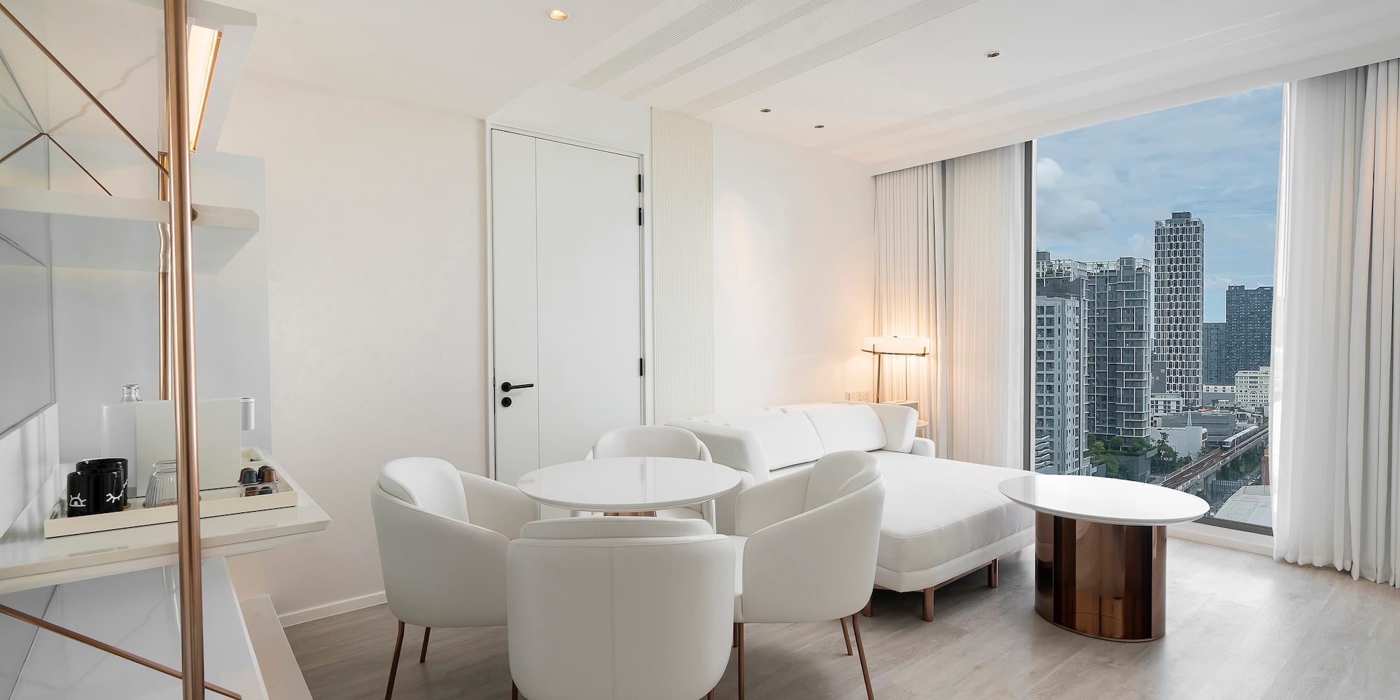 a room with white furniture and a large window