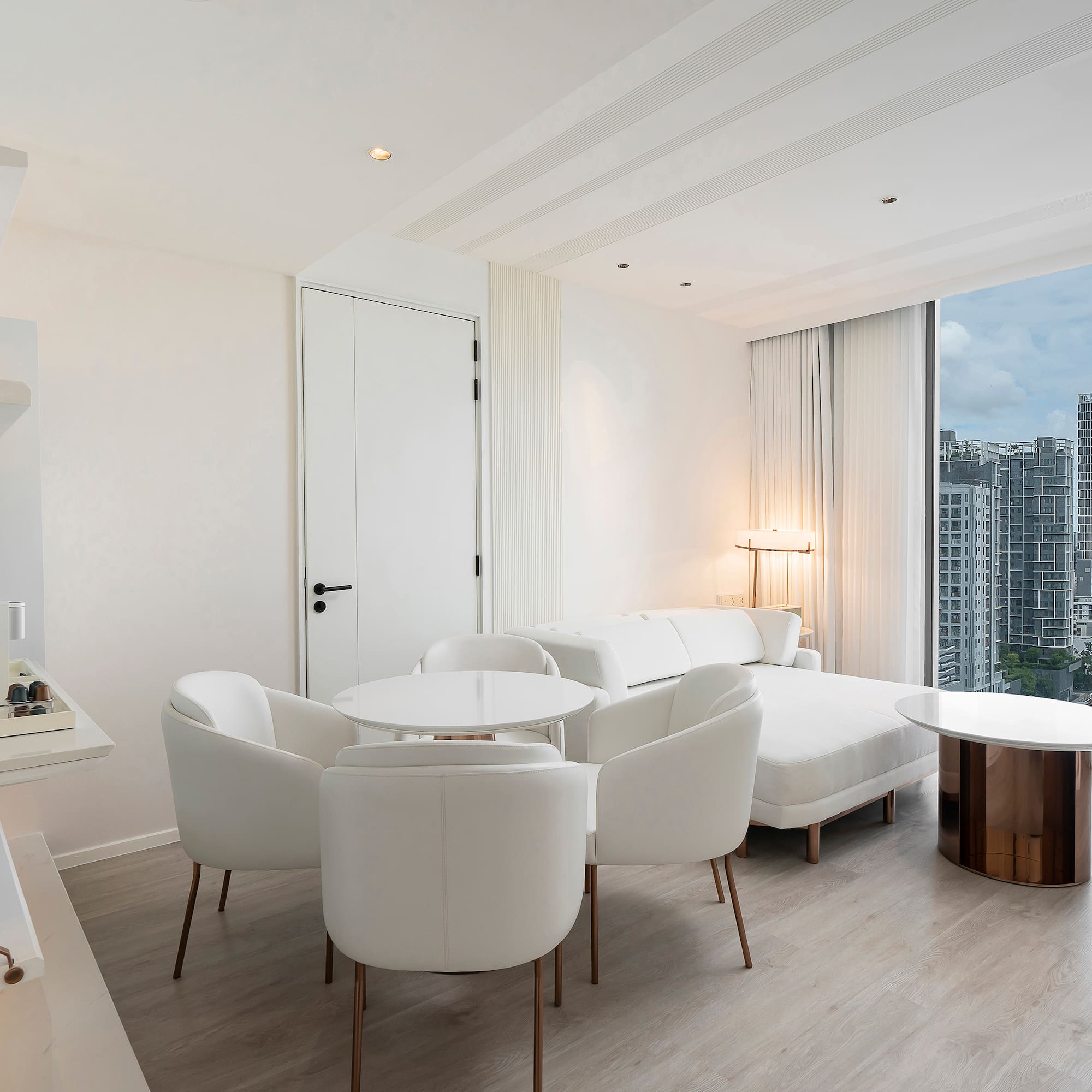 a room with white furniture and a large window