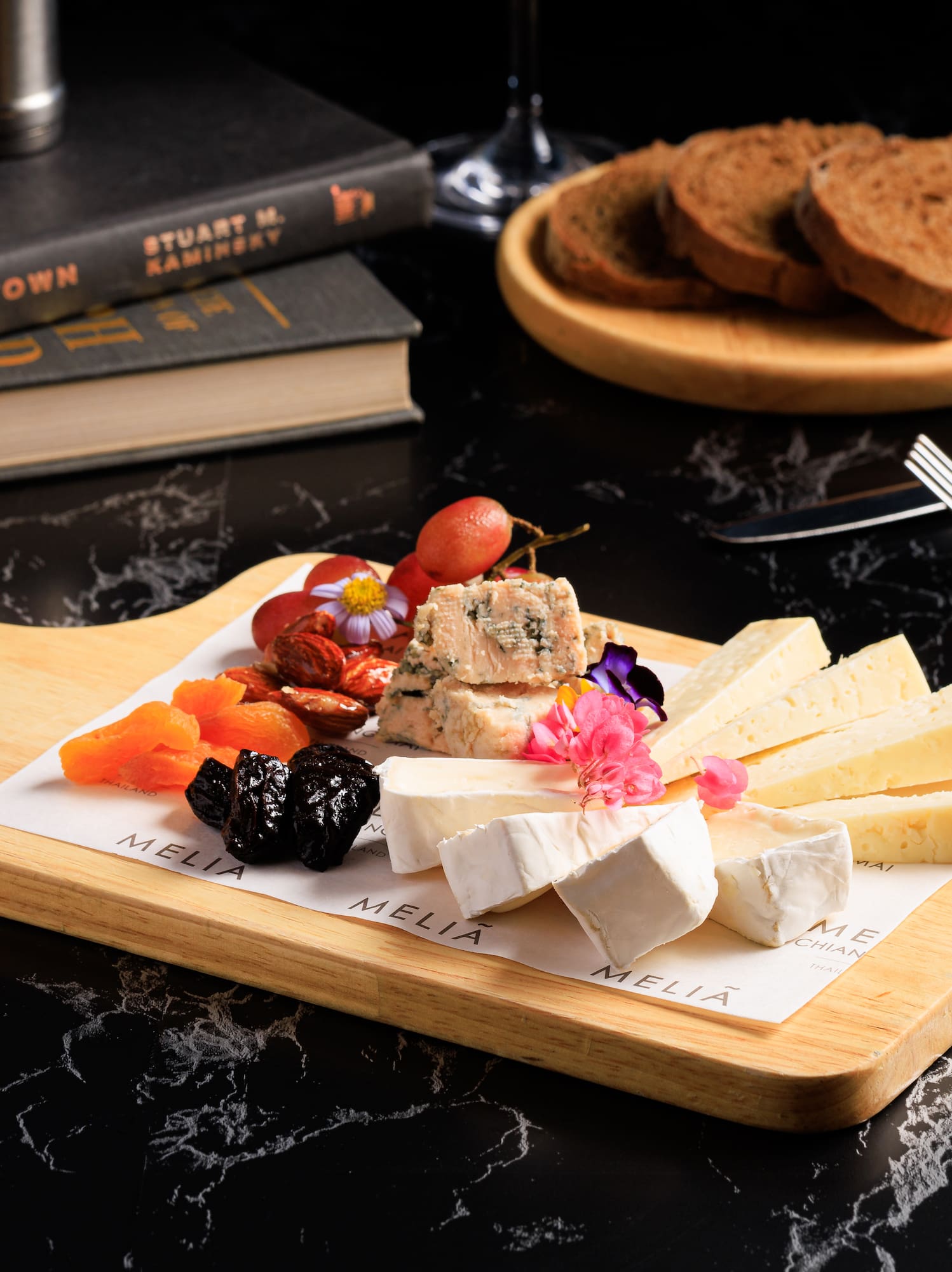 a board with cheese and fruit on it