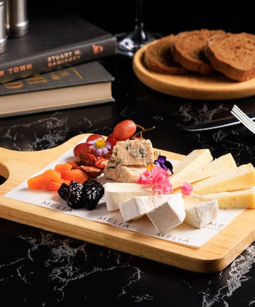 a board with cheese and fruit on it