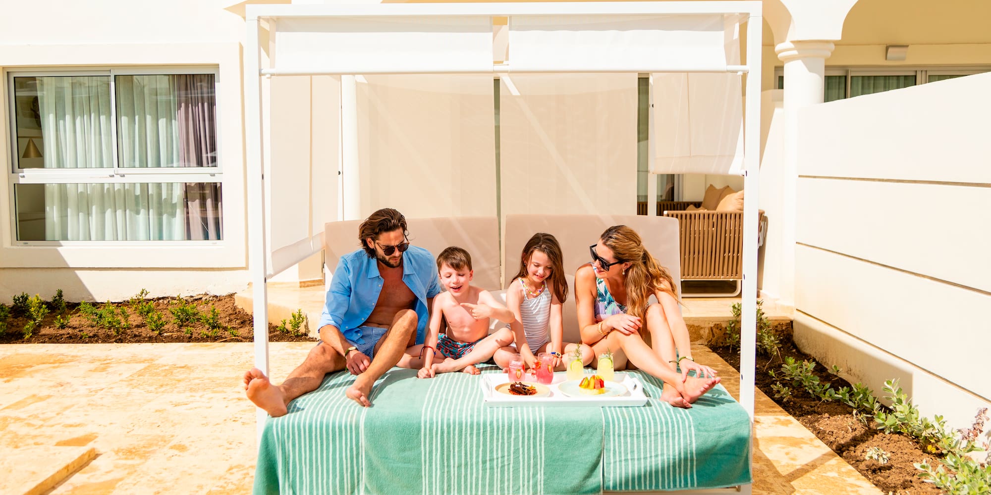 een groep mensen zittend op een bed met eten erop