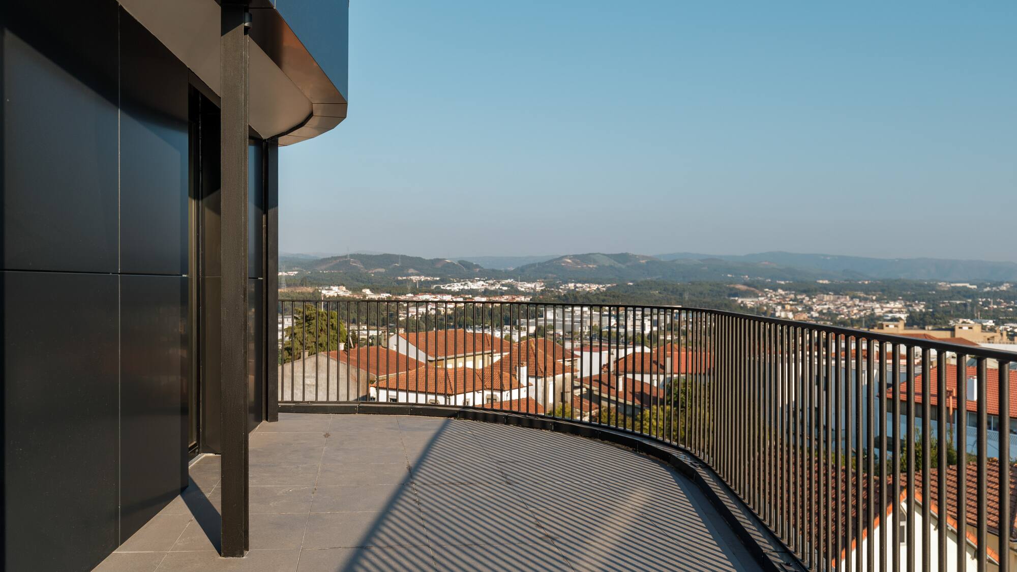 a balcony with a railing overlooking a city