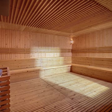 a wooden sauna with a light shining on the ceiling