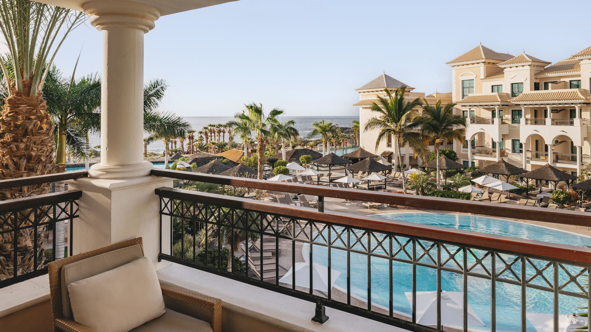 a balcony with a pool and chairs