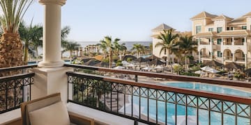 a balcony with a pool and chairs