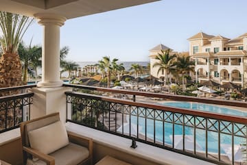 a balcony with a pool and chairs