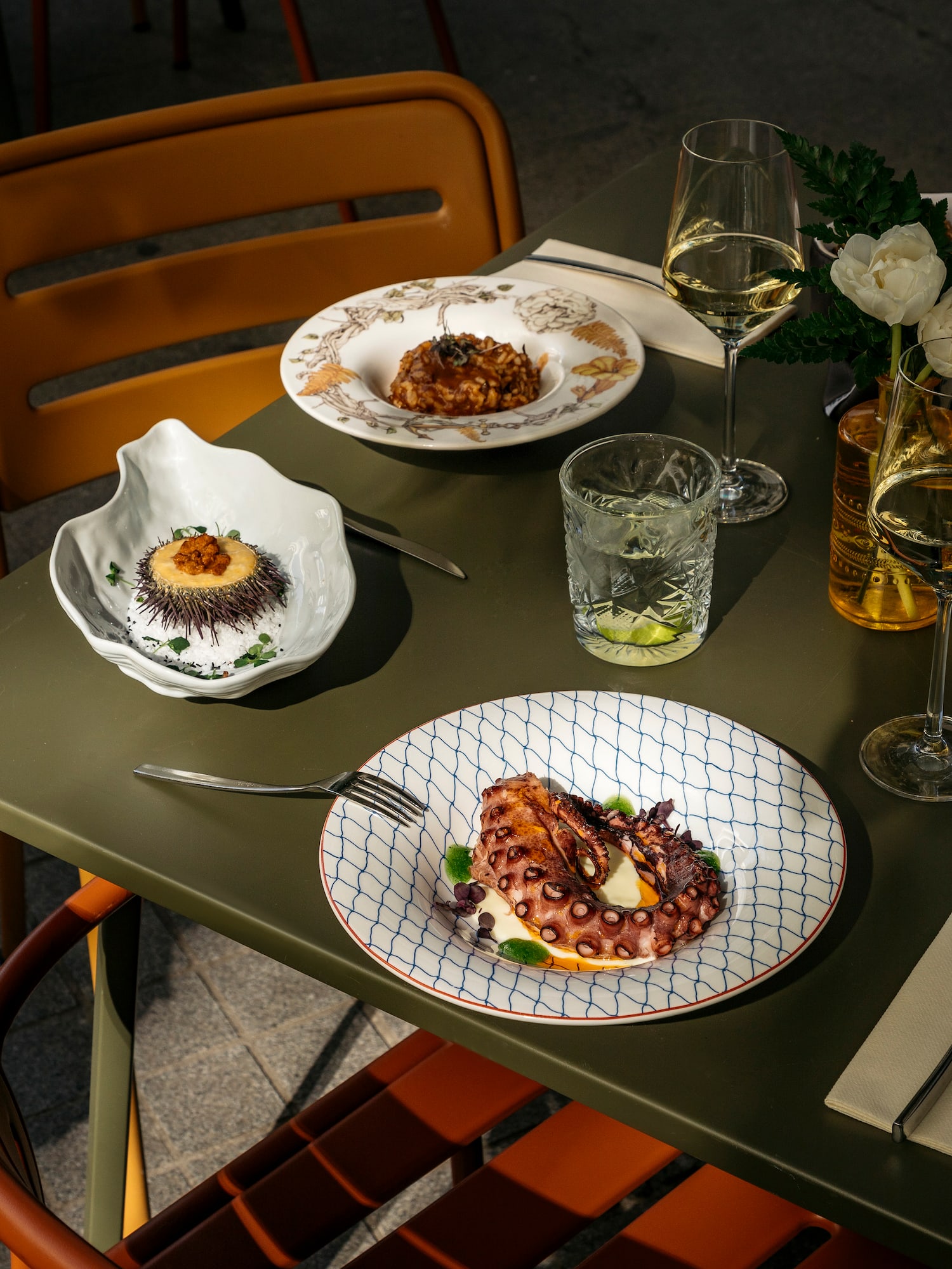 a table with plates of food and glasses of wine