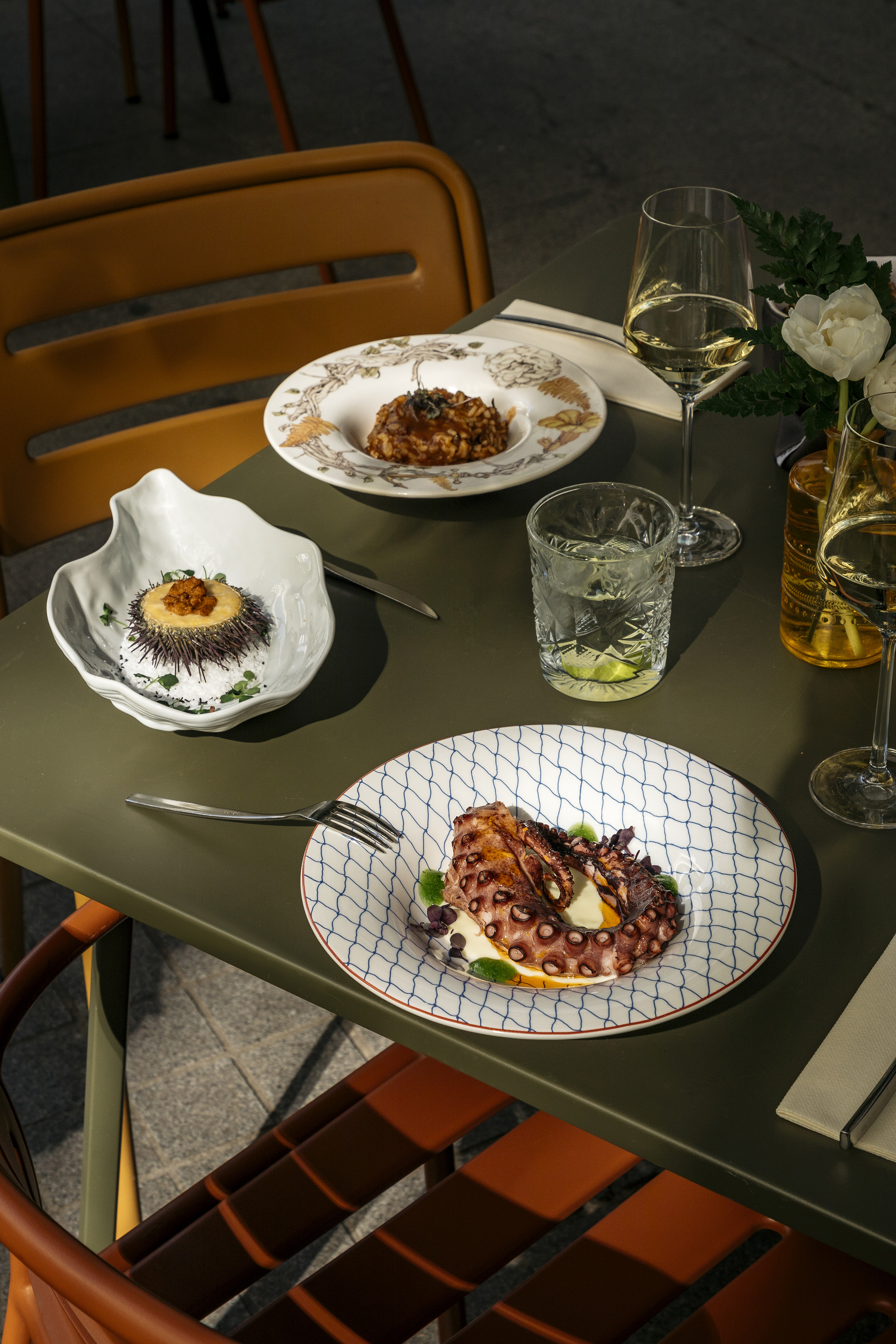 a table with plates of food and glasses of wine