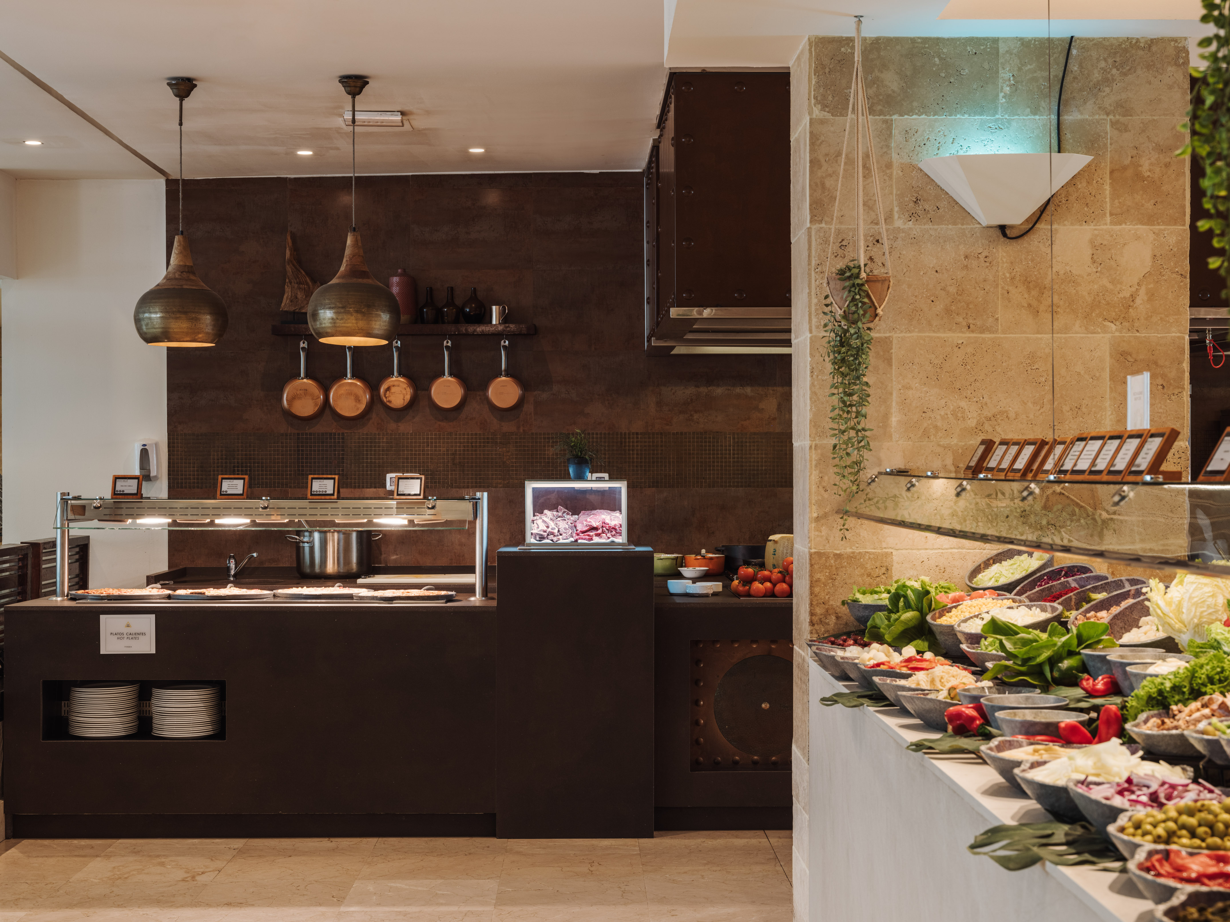 Hotel buffet with hot food, cold meat display, and fresh salad bar.