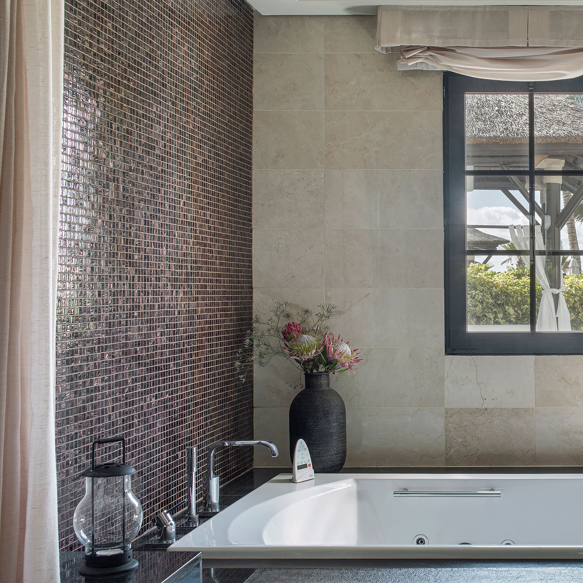 a bathroom with a tub and a vase of flowers