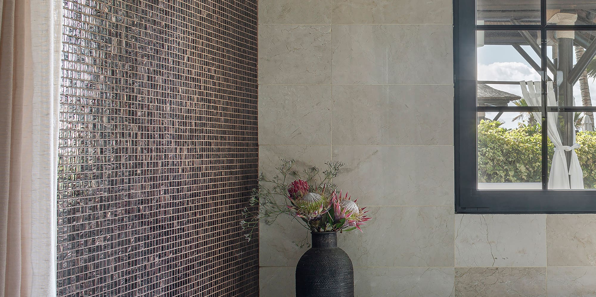 a bathroom with a tub and a vase of flowers