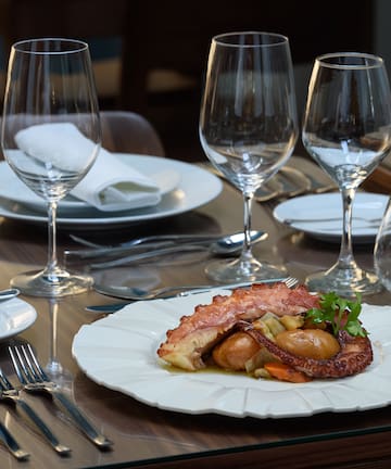 a plate of food on a table with wine glasses