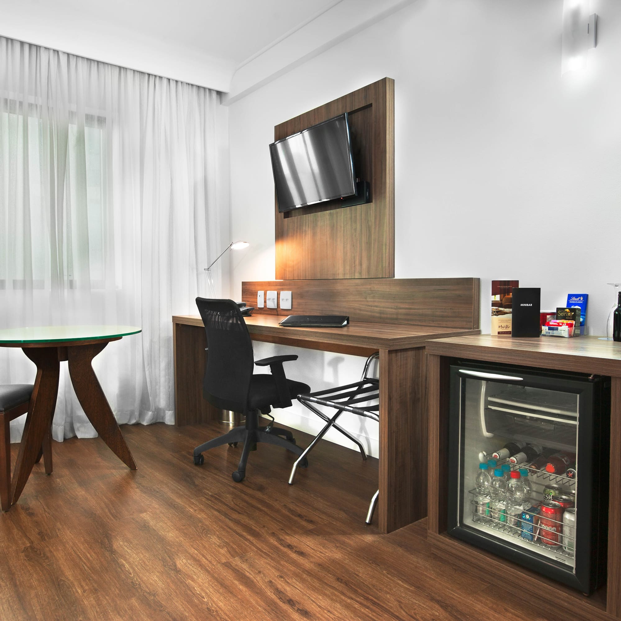 a room with a desk and a refrigerator