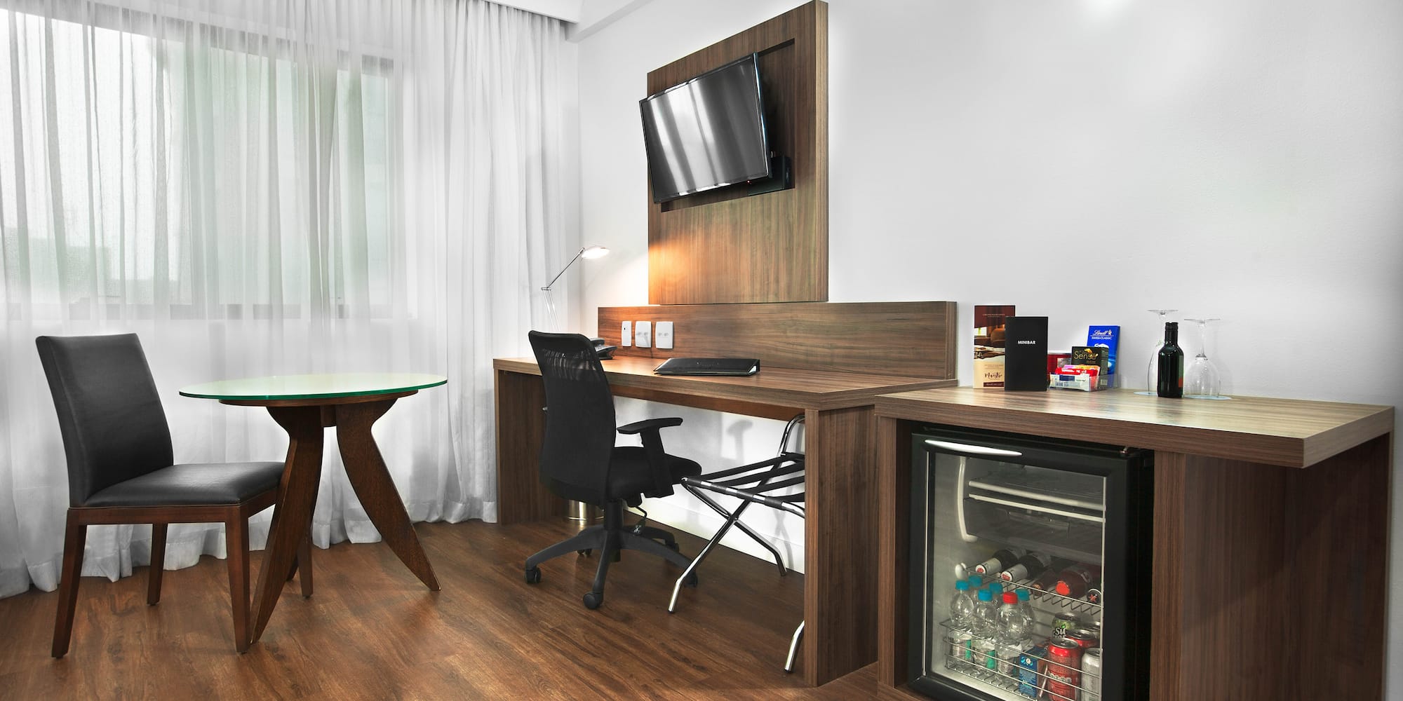 a room with a desk and a refrigerator