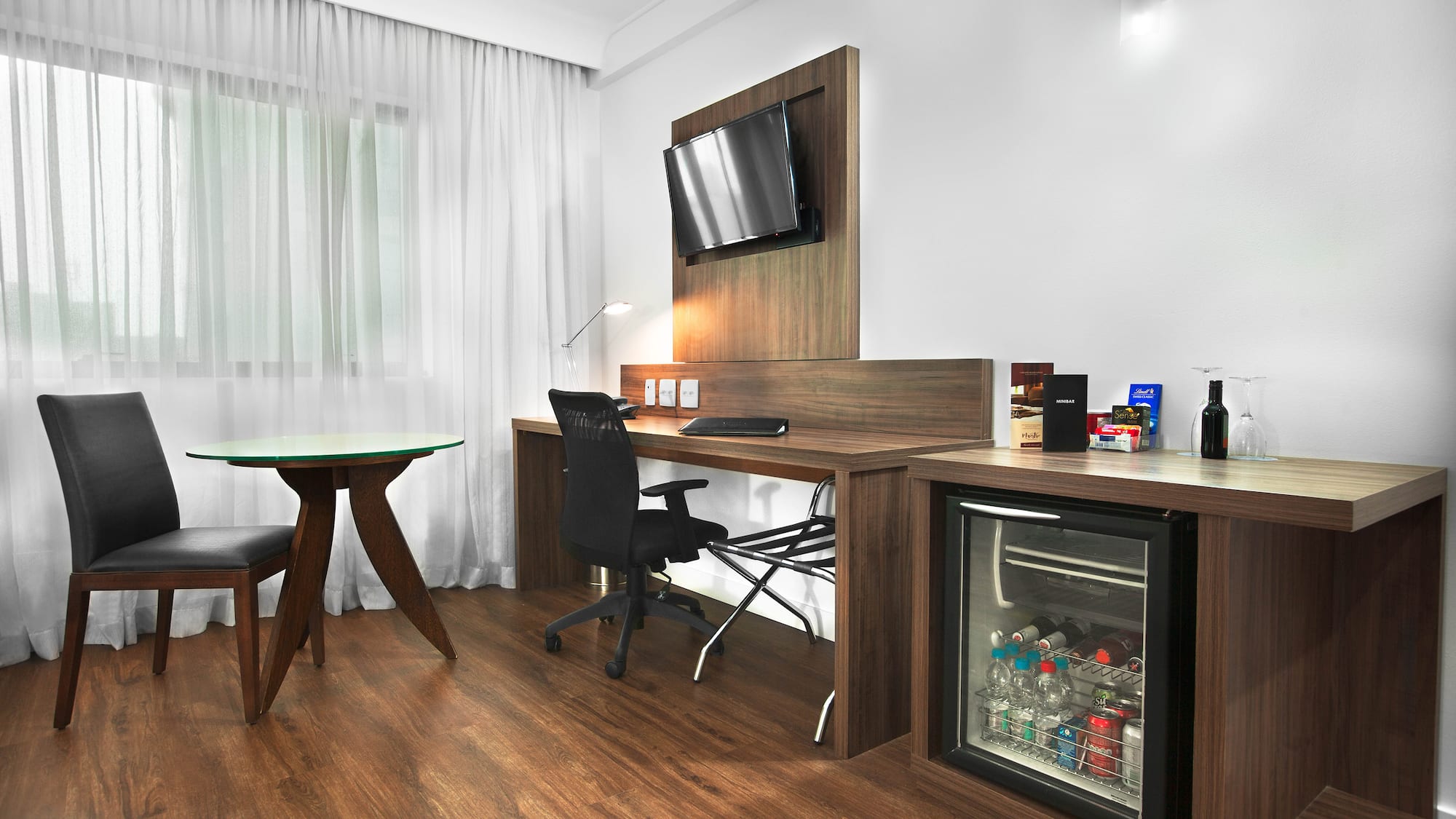 a room with a desk and a refrigerator