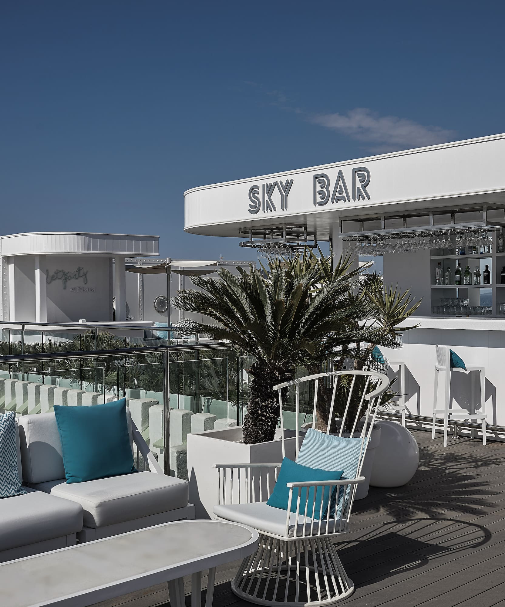 a white bar with blue pillows and chairs