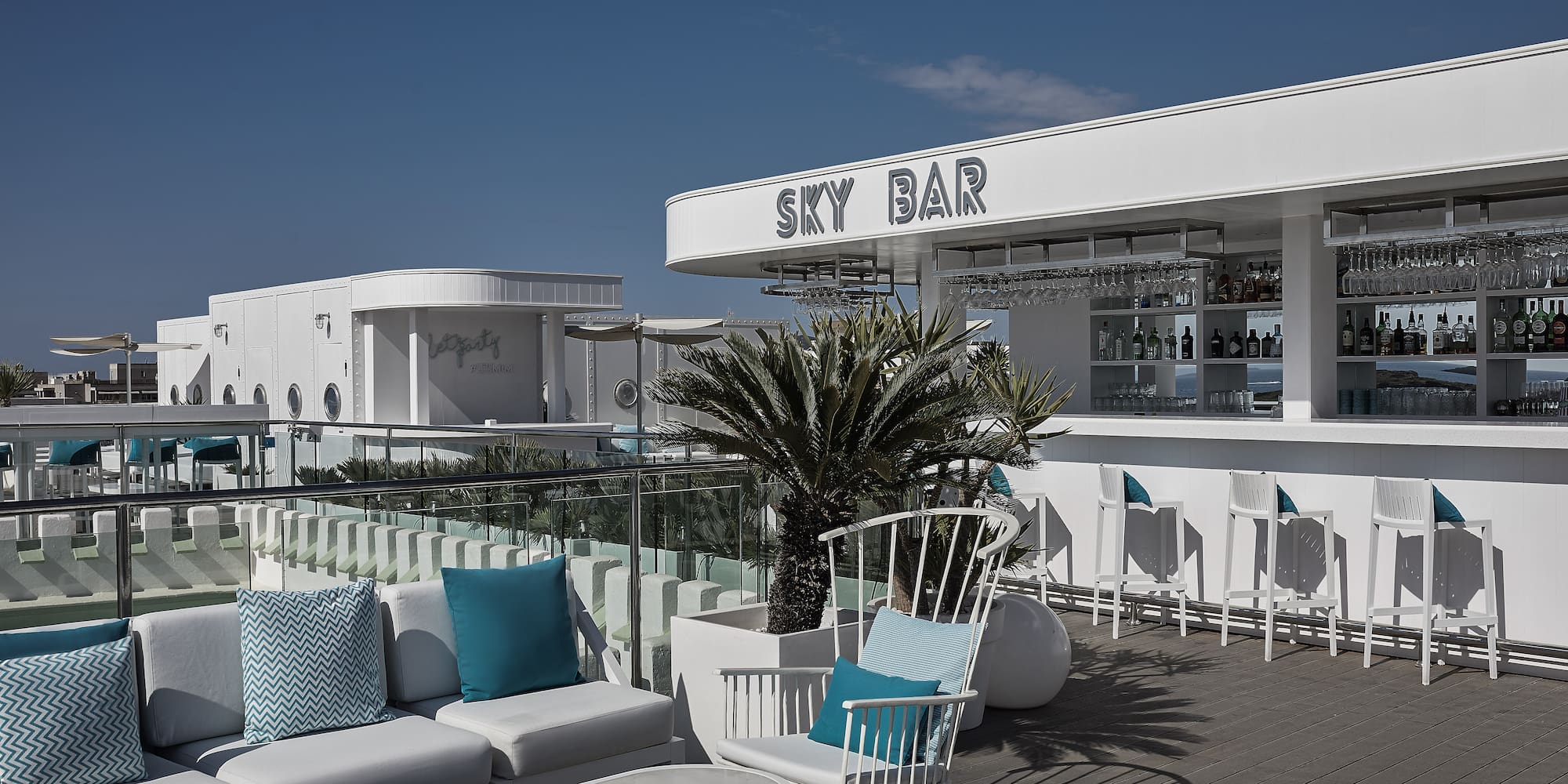 a white bar with blue pillows and chairs