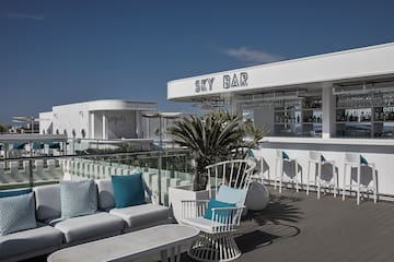 a white bar with blue pillows and chairs