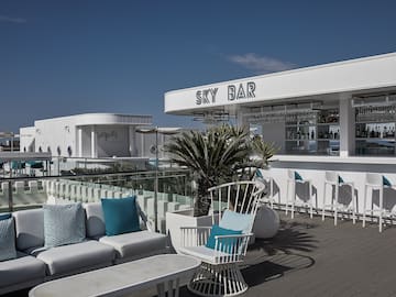 a white bar with blue pillows and chairs