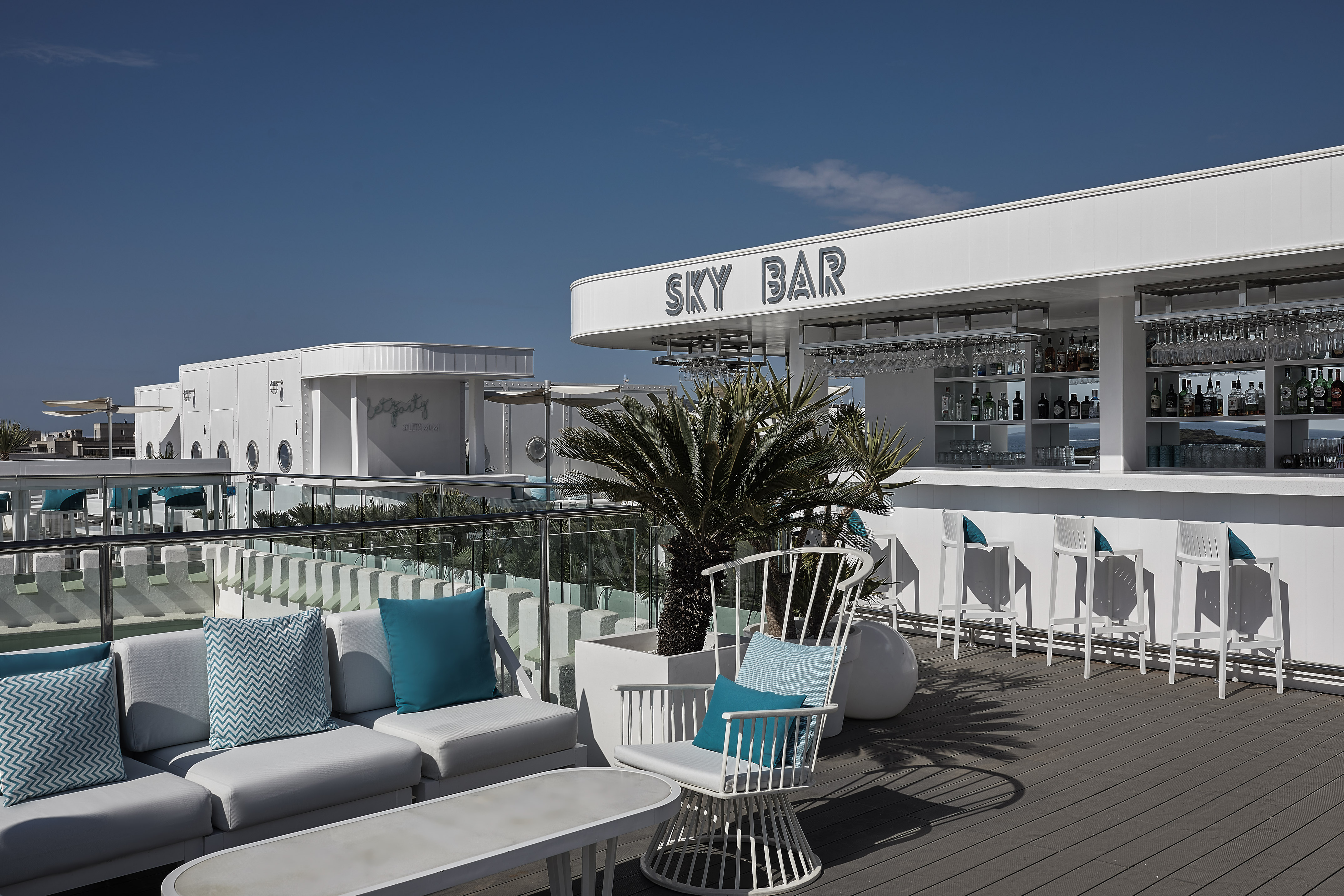 a white bar with blue pillows and chairs