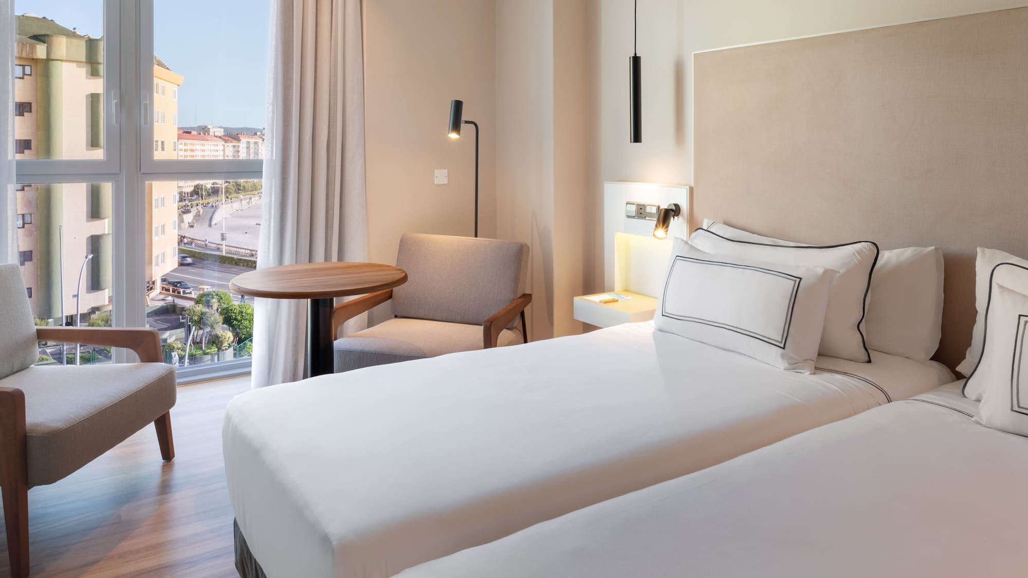 a room with two beds and a table and chairs