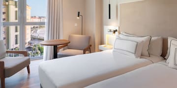 a room with two beds and a table and chairs