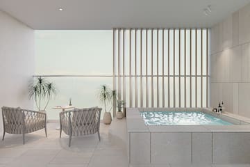 a room with a hot tub and chairs