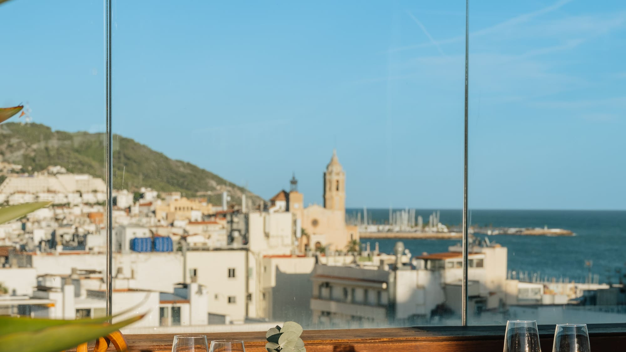 a table with glasses and a view of the city from a window