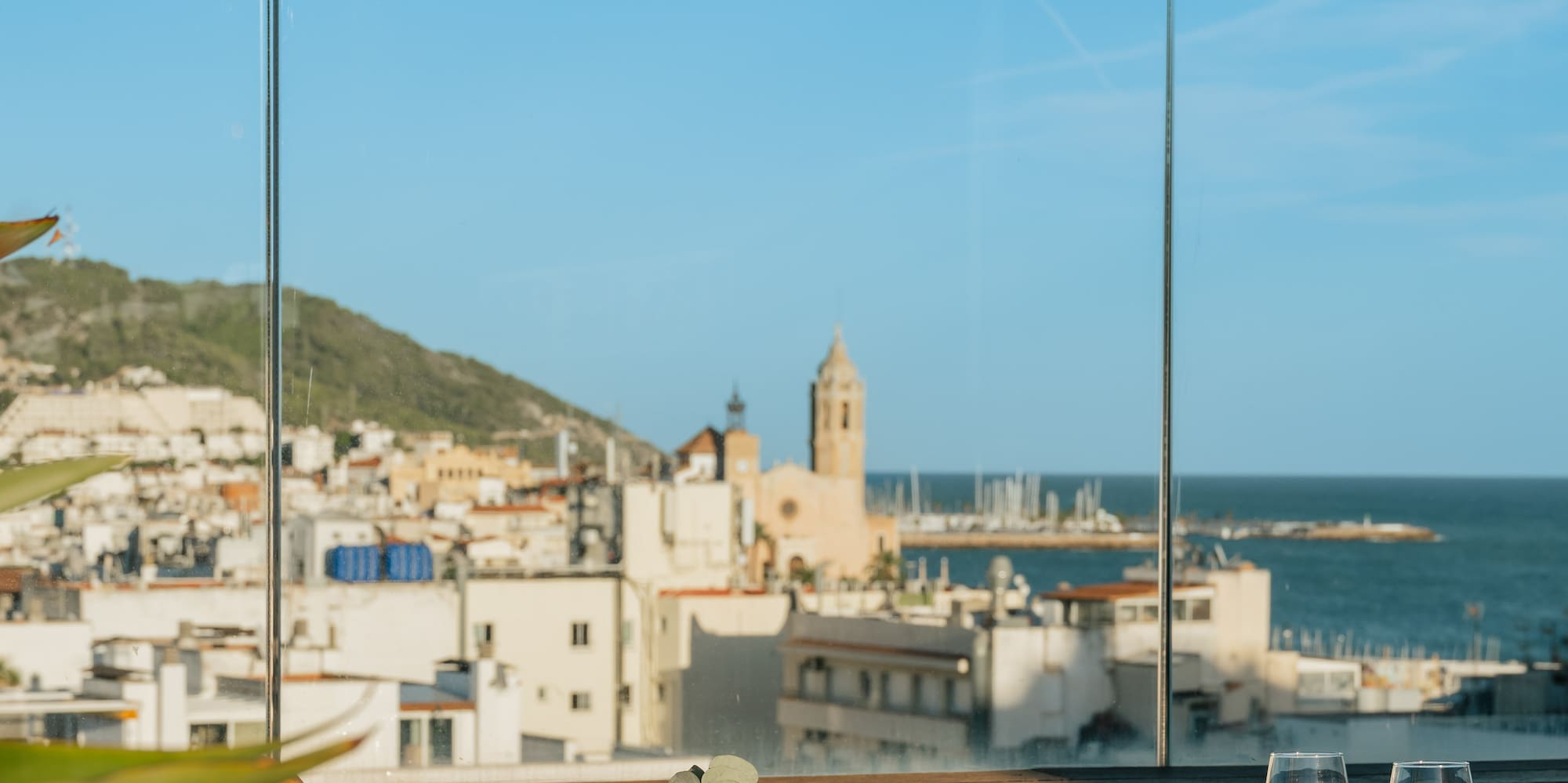 a table with glasses and a view of the city from a window
