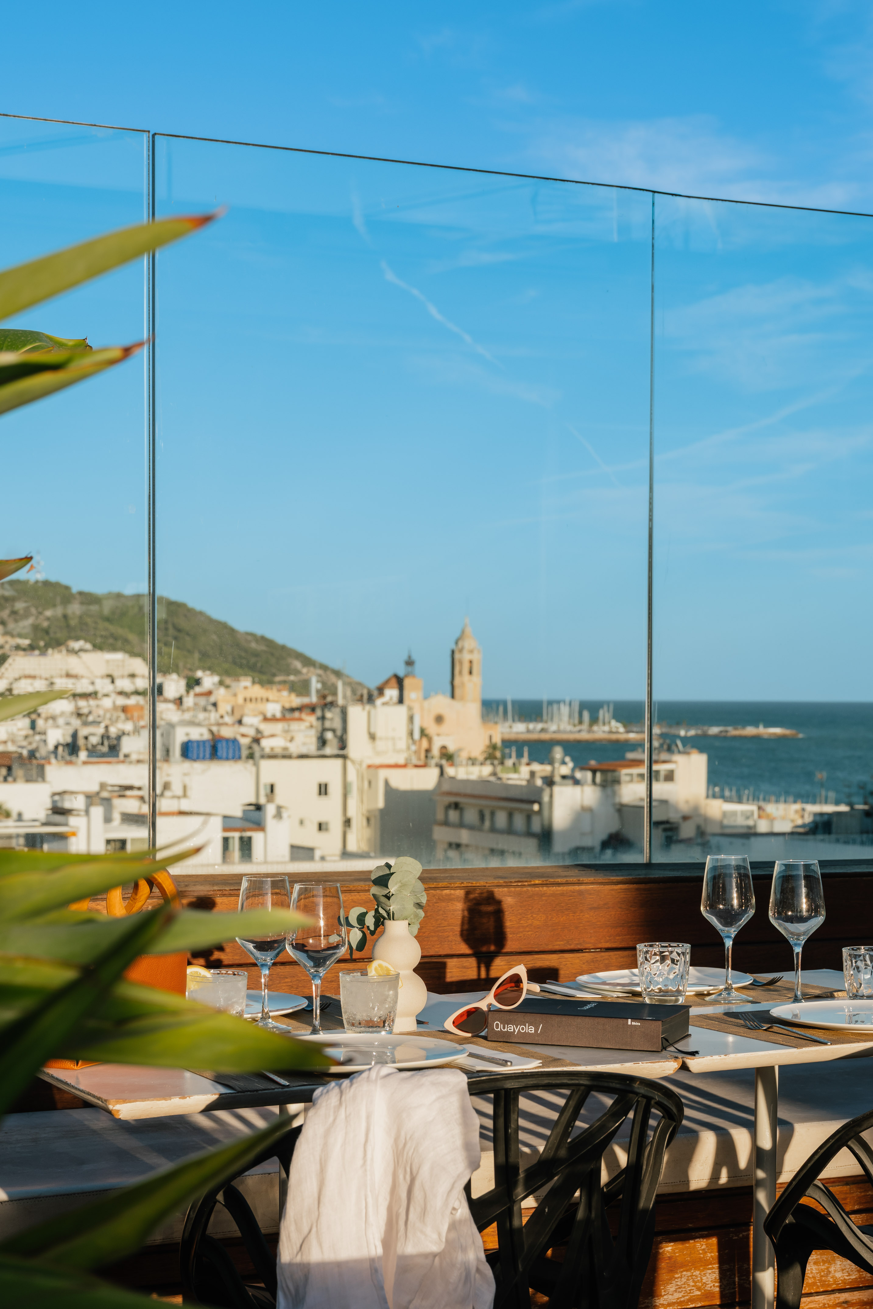 a table with glasses and a view of the city from a window