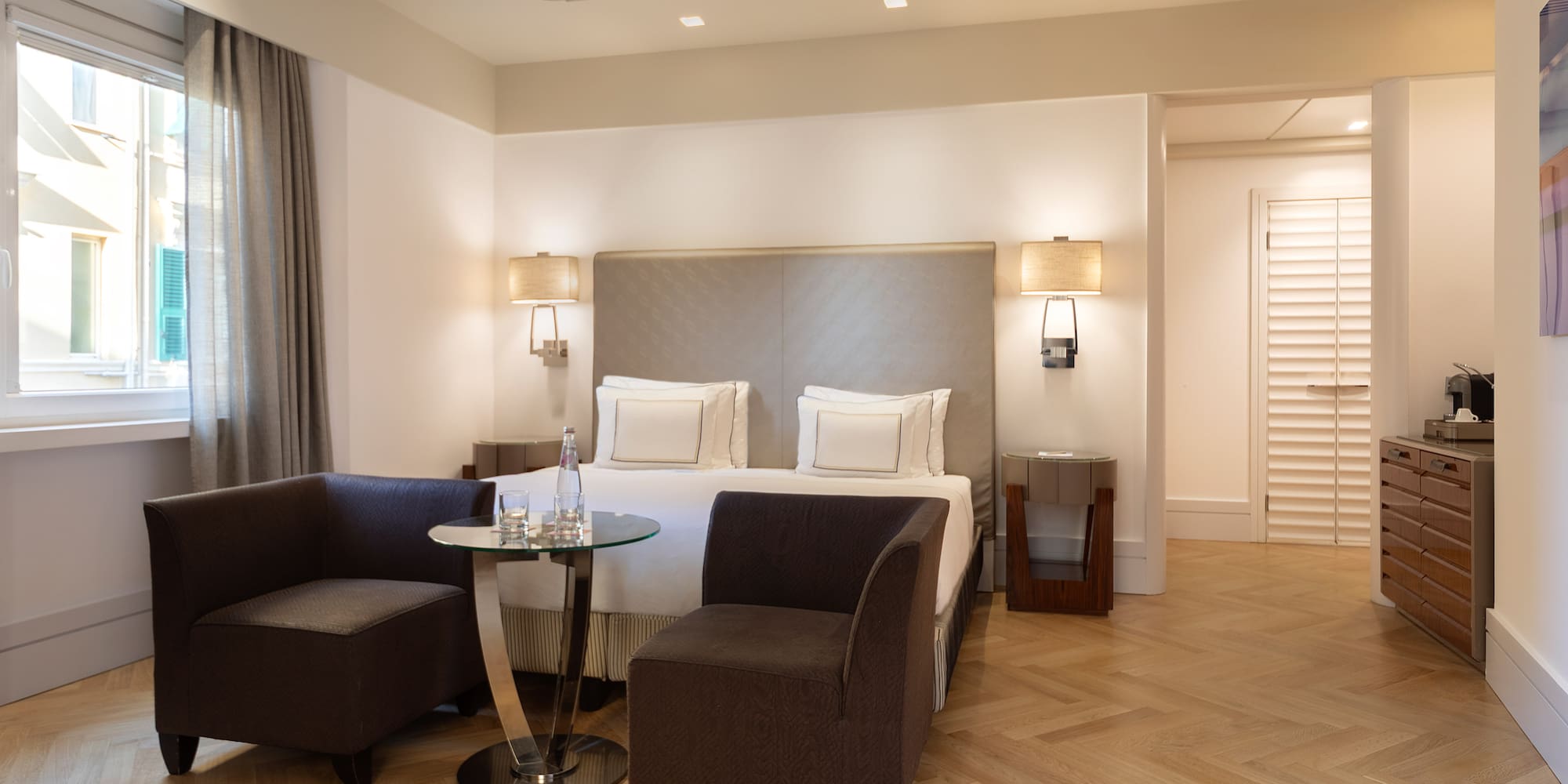 a room with a bed and chairs